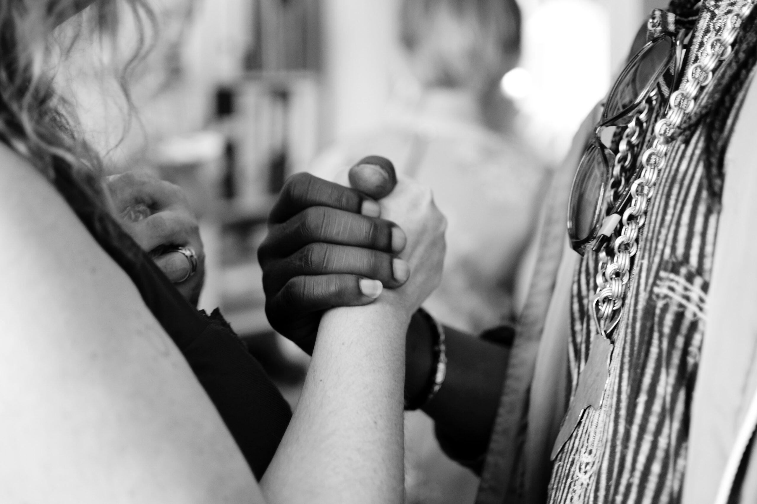 Black person and White person holding hands